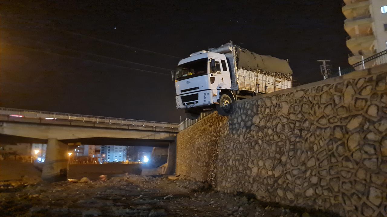 Odun yüklü kamyon istinat duvarında asılı kaldı, sürücü bulunamadı